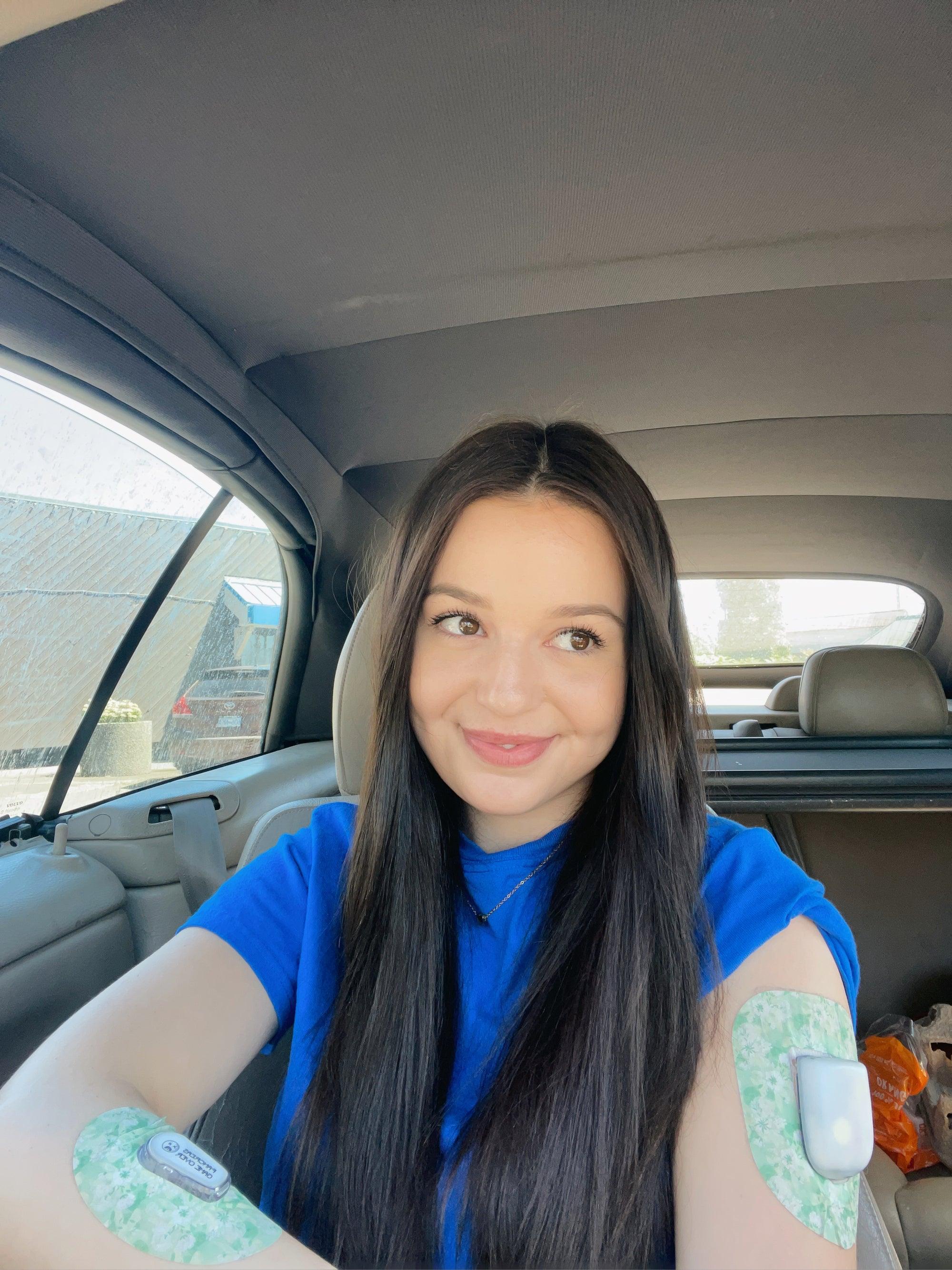 Woman in car with airy florals pod tape on arm