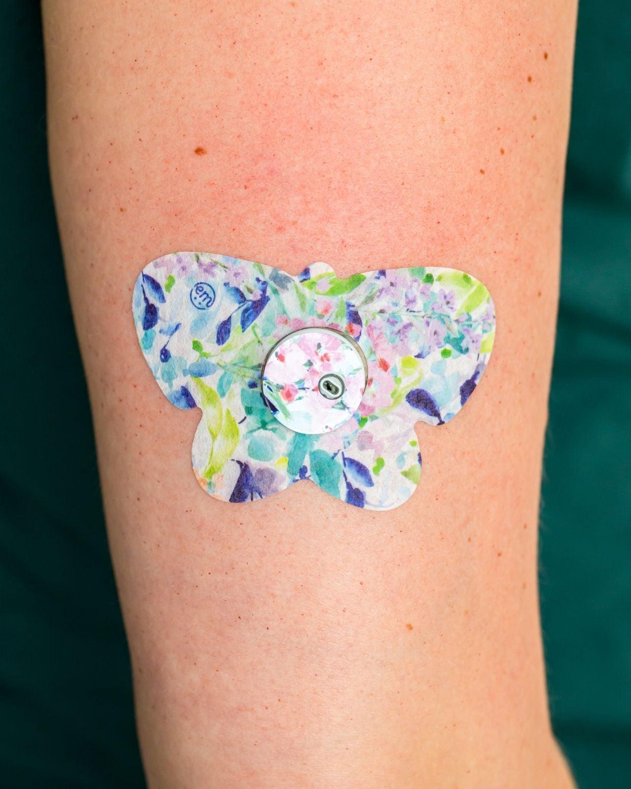 ExpressionMed, Subdued Tropics Libre 3 Butterfly Tape, Tape & Sticker, Human Wearing Subdued Tropics Themed CGM Adhesive Patch Design.