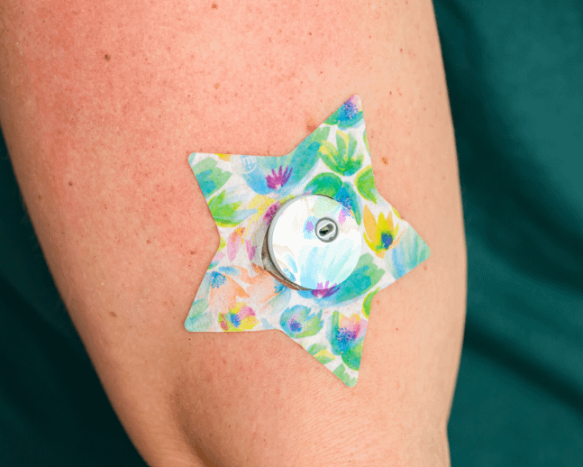 ExpressionMed, Happy Go Lucky Flowers Libre 3 Transmitter Sticker, Tape & Sticker, Human Wearing Happy Go Lucky Flowers Themed CGM Adhesive Patch Design