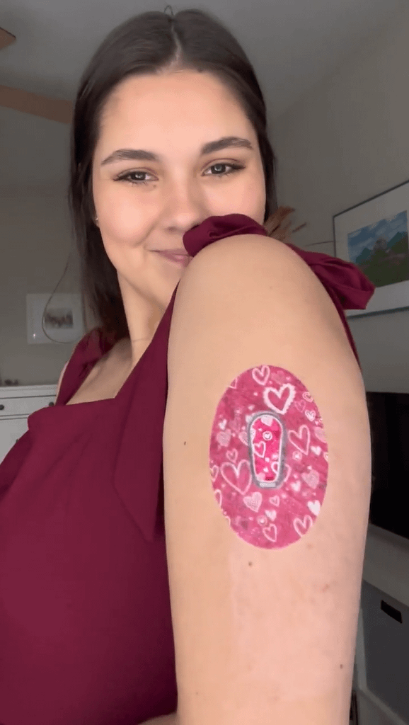 Woman with Whimsical Hearts Dexcom G6 Tape and Transmitter Sticker on arm