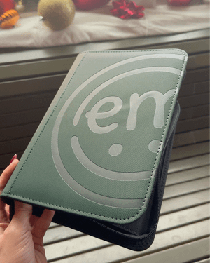 A stylish green storage book held in a hand, showing off its compact and portable design.
