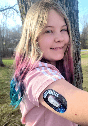 Girl outside with Aquarius Dexcom G6 Mini Tape on arm