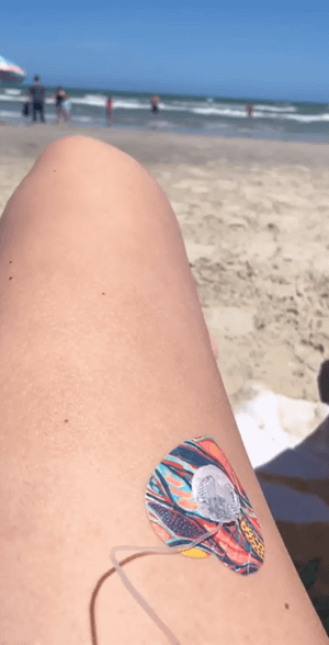 Woman at beach with twisted seaweed heart infusion set tape on leg