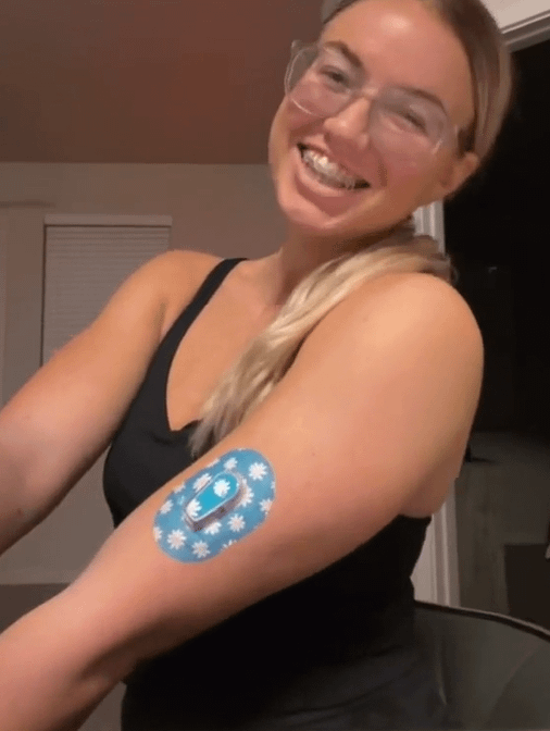 ExpressionMed Woman with Painted Daisies Dexcom G6 Mini Tape and Transmitter Sticker on arm