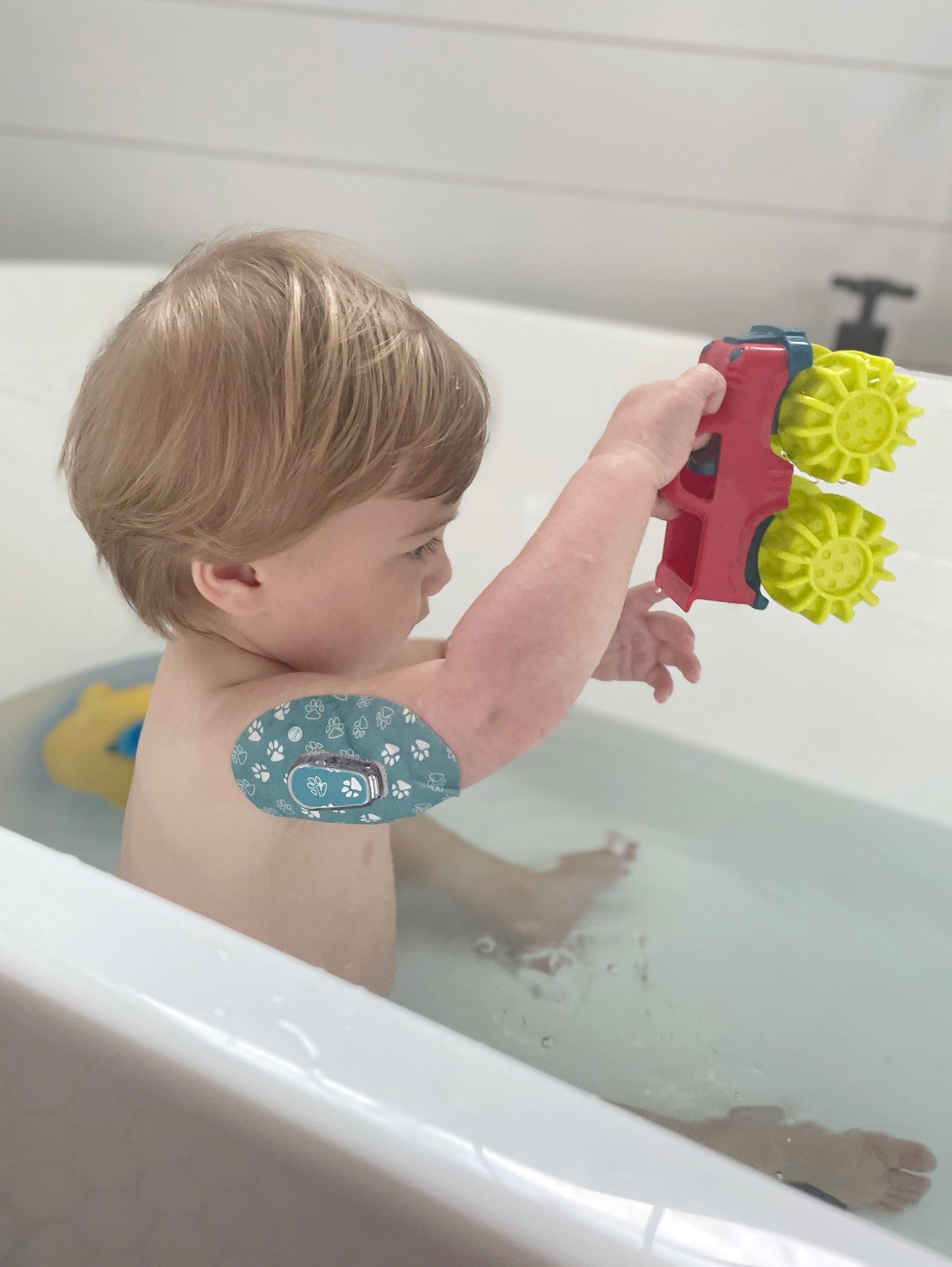 ExpressionMed Little boy playing in the tub with Pawprint Dexcom G6 Tape and Transmitter Sticker on his arm